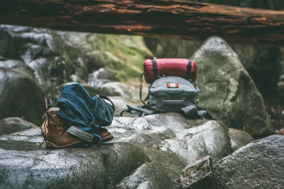 Two gray and orange backpacks on rocks
