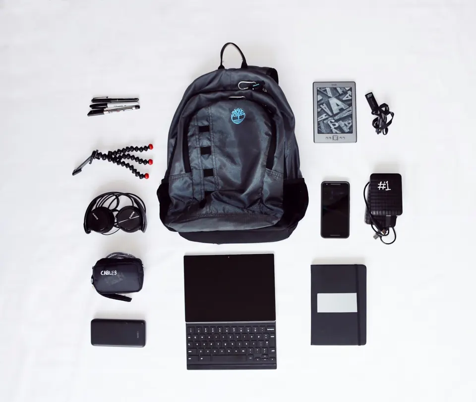 Flat lay of backpack, laptop computer, headphones and smartphone