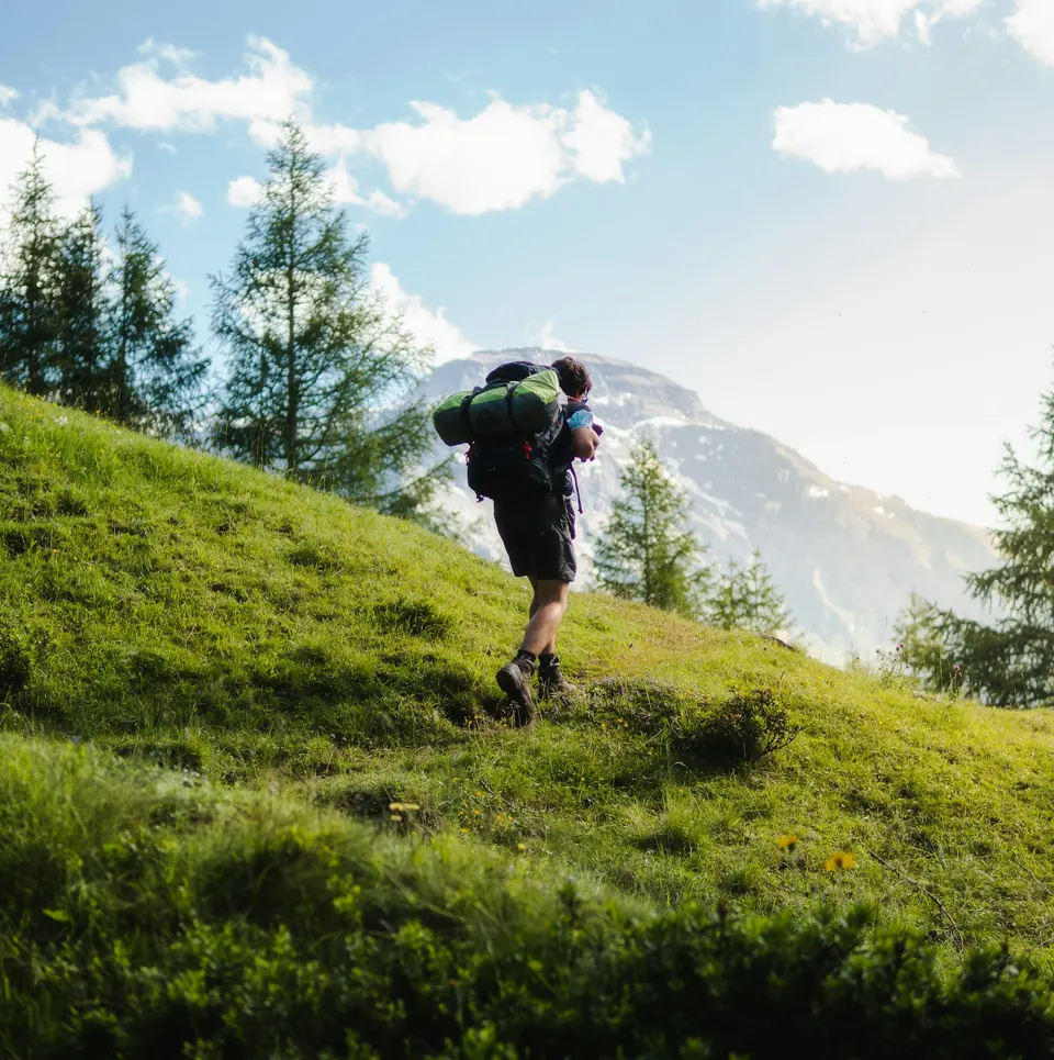 Man with black backpack in a field