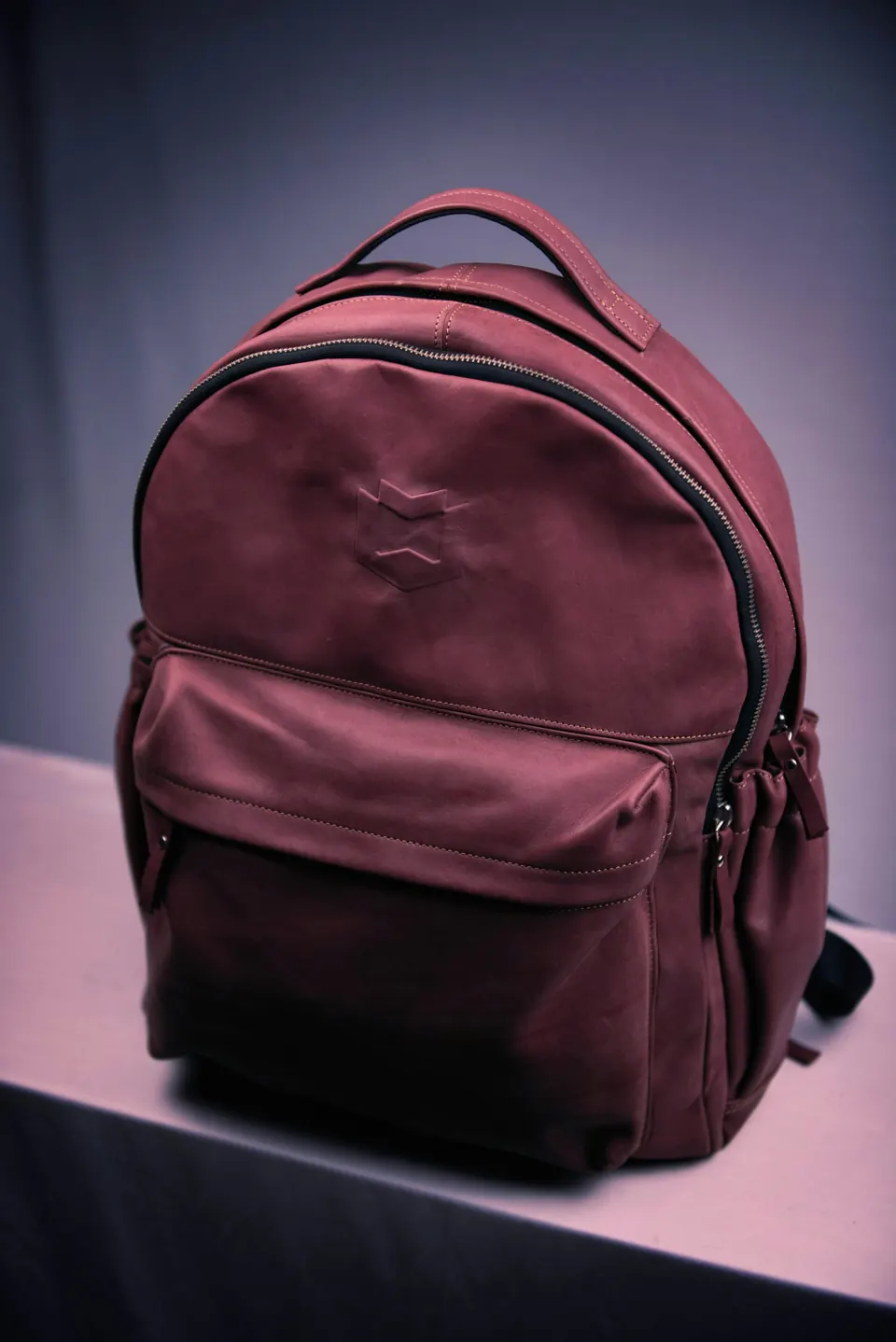 Brown leather backpack on white table