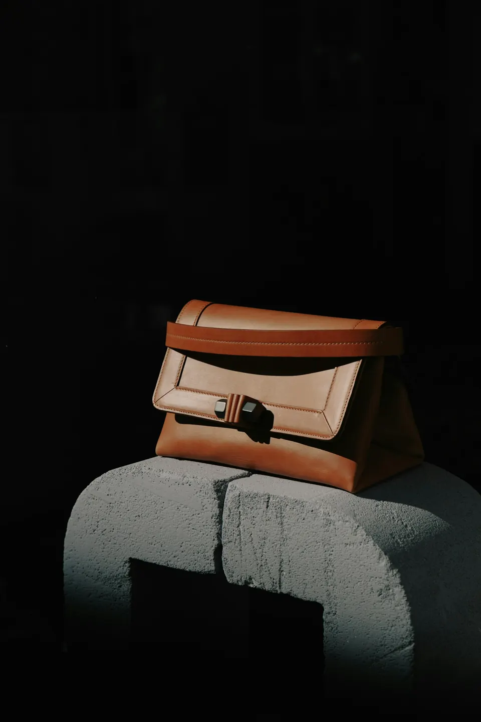 Brown and black leather bag on gray textile