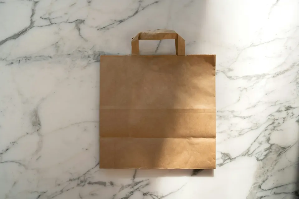 A brown paper bag on a marble counter