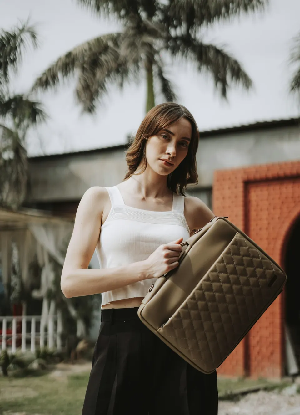 A woman holding a brown suitcase in her hands
