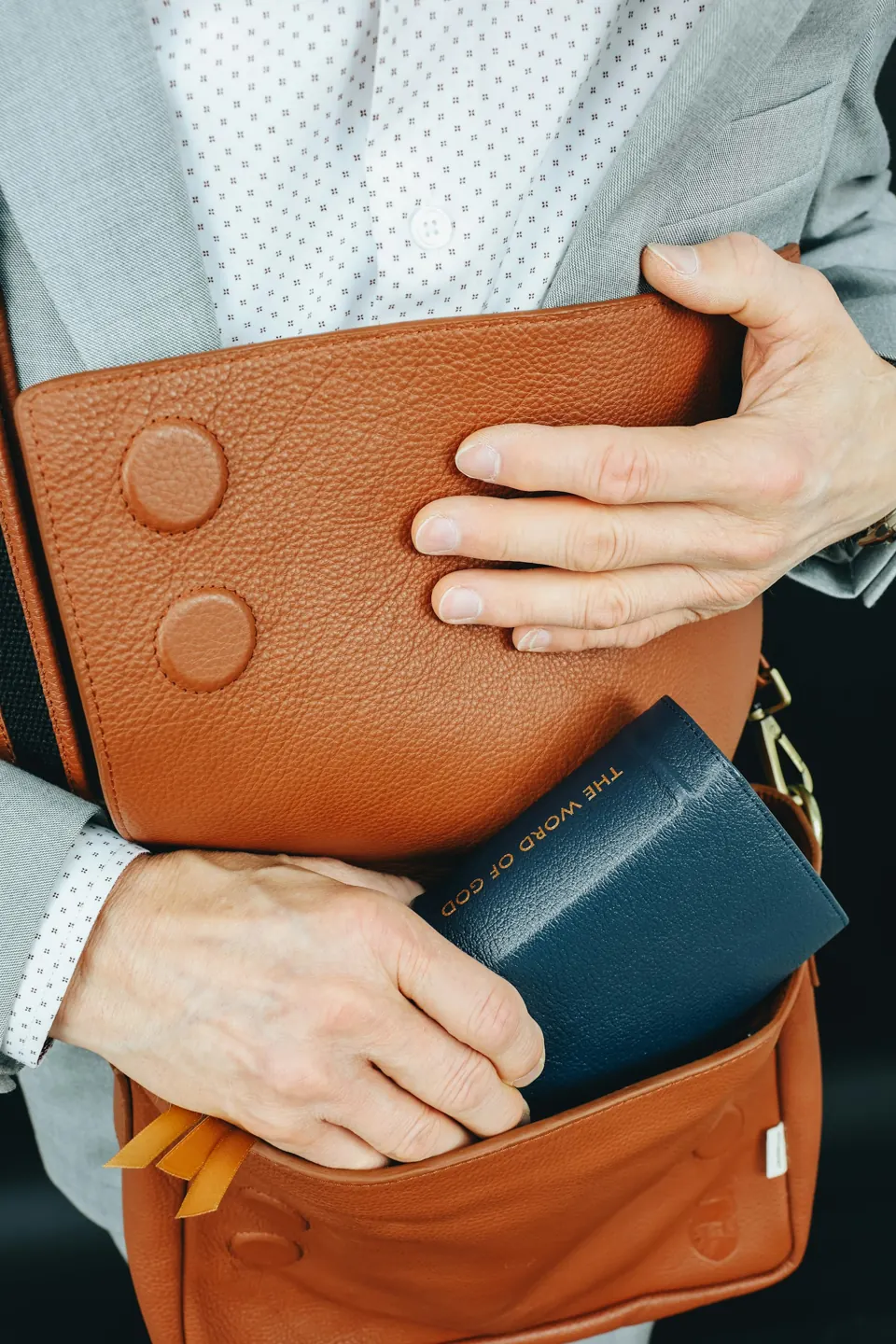 A man in a suit holding a brown briefcase