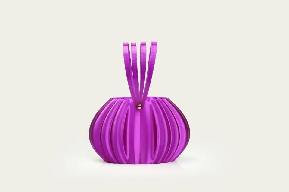 A purple pleated handbag with ribbon handles